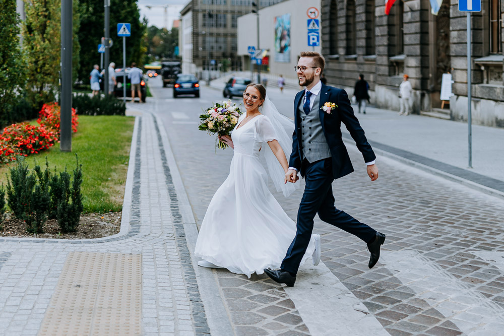 Młoda para pozuje do zdjęć podczas miejskiej sesji ślubnej w centrum Poznania