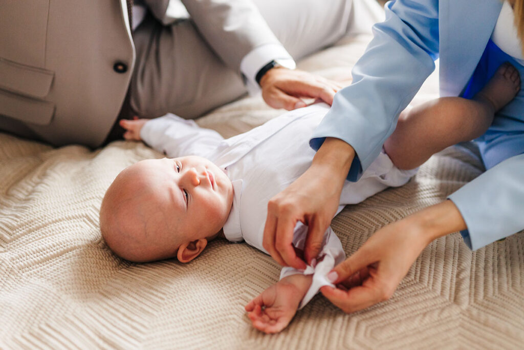 fotografia chrztu poznań, dziecko podczas ubierania do chrztu