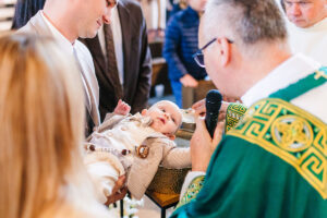 fotografia chrztu poznań - dziecko podczas chrztu w kościele